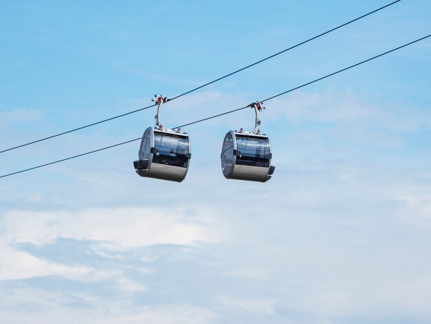 Duas cabines de teleférico lado a lado contra o céu azul