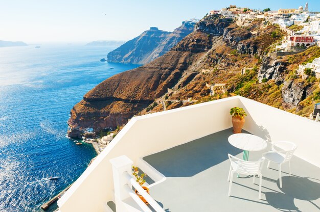 Duas cadeiras com mesa no terraço com vista para o mar. Ilha de Santorini, Grécia