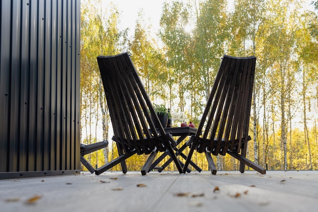 Duas cadeiras de madeira escura no outono da paisagem do terraço