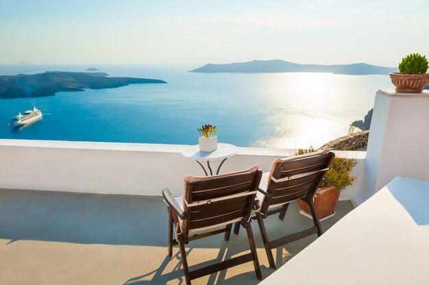 Duas cadeiras no terraço com vista para o mar. Ilha de Santorini, Grécia ao pôr do sol