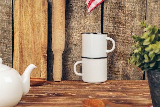 Duas canecas de chá branco vintage e bule no balcão da cozinha