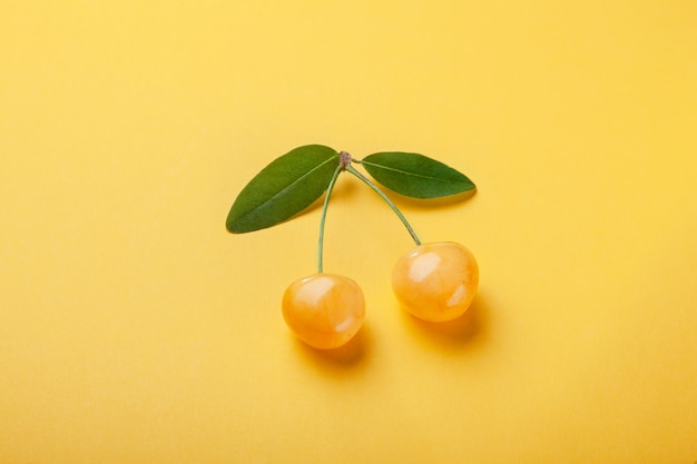 Duas cerejas amarelas com folhas verdes