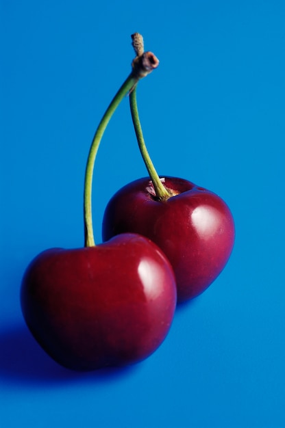 Foto duas cerejas com fundo azul