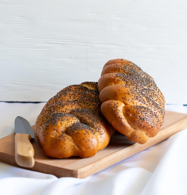 Duas chalá com sementes de papoila na placa de madeira Pastelaria judaica tradicional