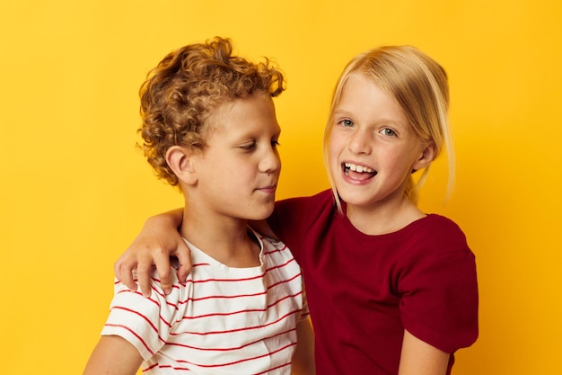 Duas crianças alegres em pé lado a lado posando fundo isolado de emoções de infância