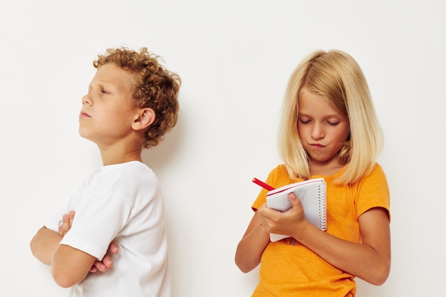 Duas crianças alegres ficam ao lado do bloco de notas desenhando emoções estilo de vida inalterado