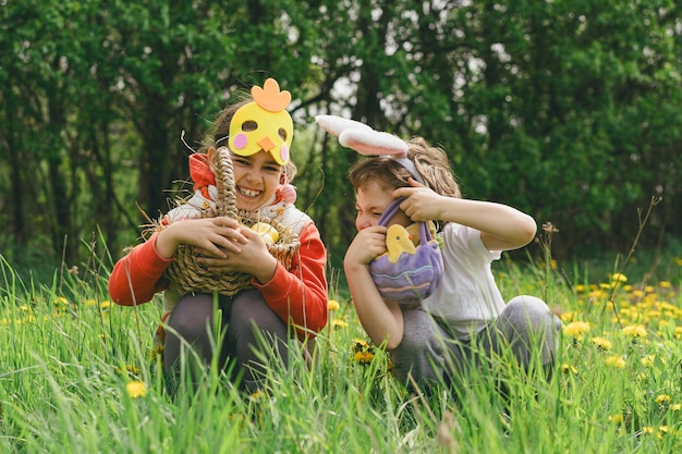 Duas crianças caçam ovos de Páscoa em um jardim de primavera Tradição da Páscoa