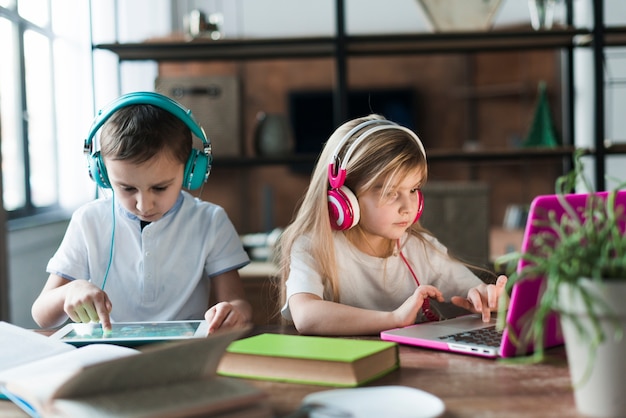 Duas crianças com laptop e tablet