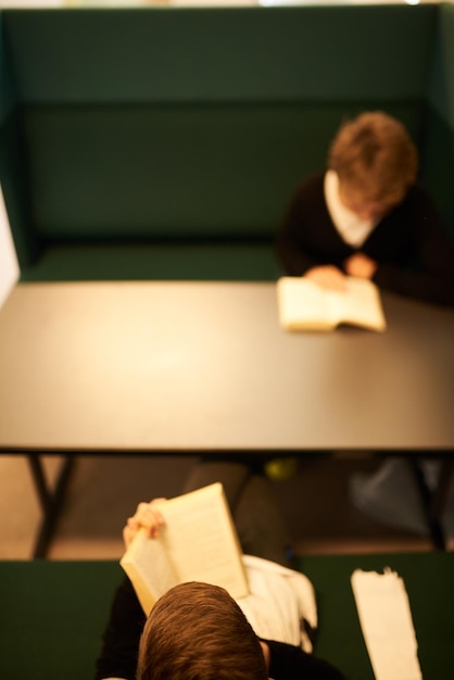 Foto duas crianças lendo um livro em um pequeno recanto