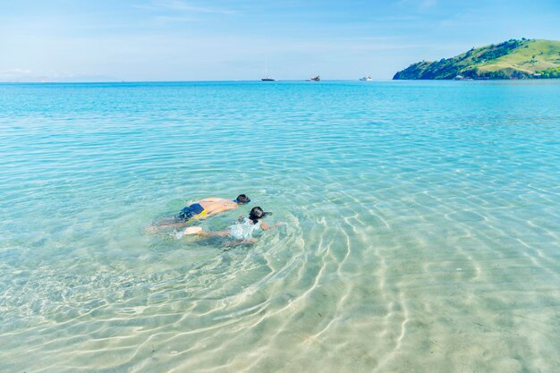 Duas crianças nadando na praia