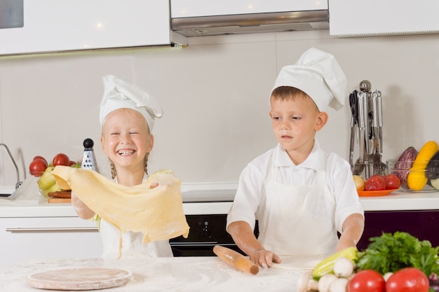 Foto duas crianças se divertindo fazendo pizza