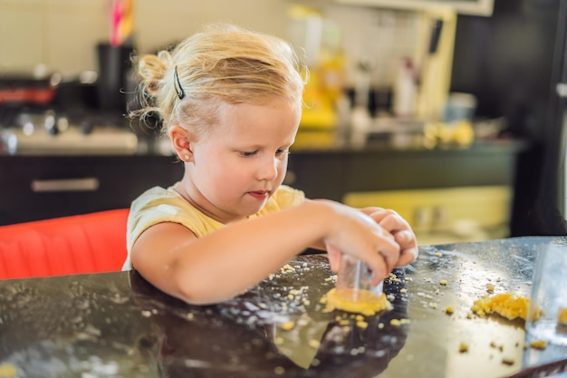 Duas crianças um menino e uma menina fazem biscoitos de massa