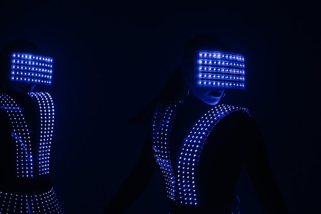 Duas dançarinas de discoteca sexy se movem em trajes de UV. Festas e danças.