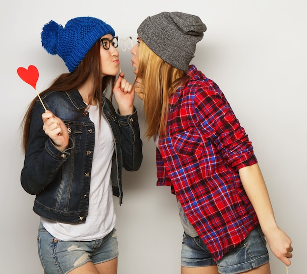 Duas elegantes melhores amigas de meninas hippie sexy prontas para a festa, sobre fundo cinza