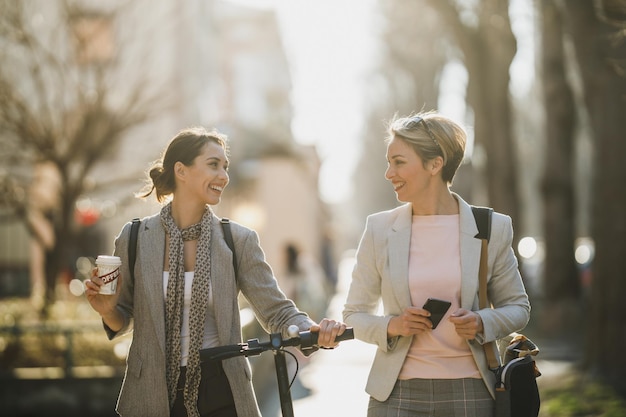 Duas empresárias de sucesso fazendo uma pausa rápida e conversando enquanto caminhavam pela cidade.