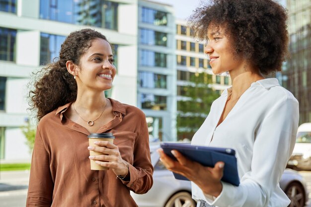 Duas empresárias felizes com tablet digital na cidade