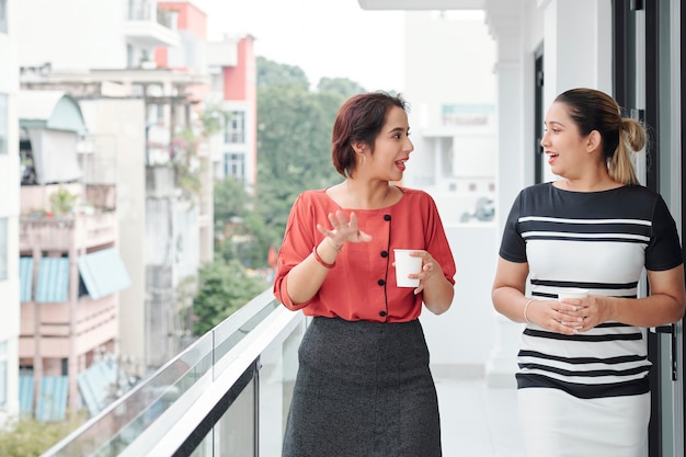 Duas empresárias tomando café na varanda