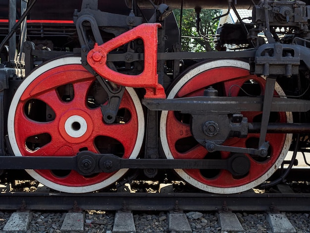 Duas enormes rodas de metal vermelho de uma velha locomotiva a vapor