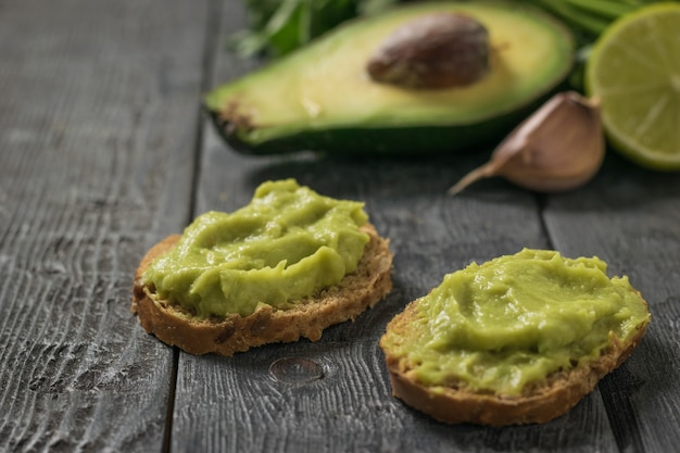 Duas fatias de pão com abacate e guacamole de alho. Abacate de comida mexicana vegetariana de dieta. Comida crua.