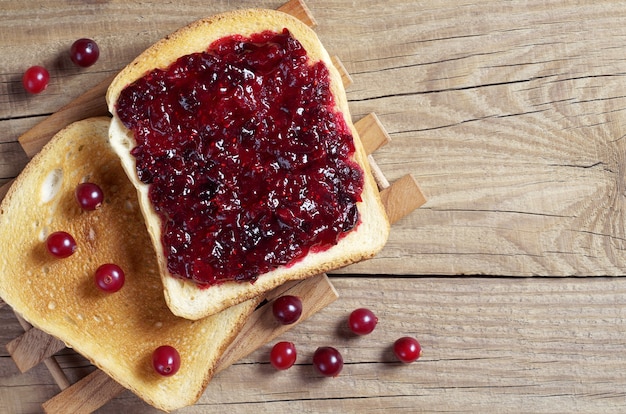 Duas fatias de pão torrado com geléia de cranberry e frutas vermelhas