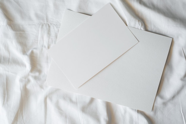 Duas folhas de papel em branco sobre o tecido, vista superior. layout com espaço de cópia