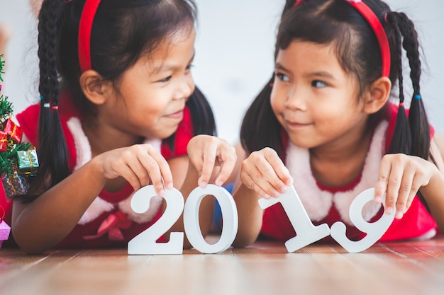 Duas garotas asiáticas bonito criança segurando números 2019 para celebrar o feriado de ano novo