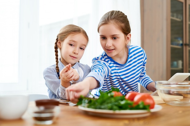 Duas garotas bonitas cozinhar em casa