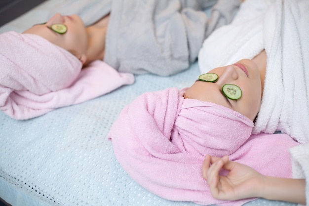 Duas garotas bonitas fazendo tratamentos de spa facial.