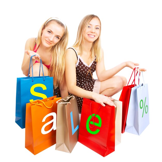 Duas garotas com sacos - compras de comparação. Oferta!