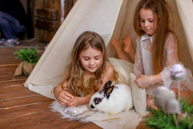 duas garotas em uma tenda wigwam com um coelho, tema de páscoa