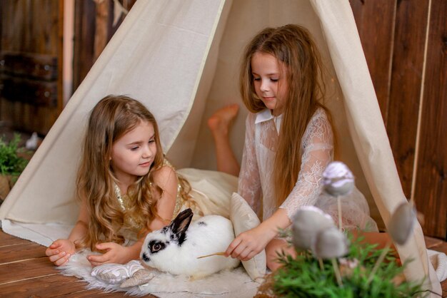 duas garotas em uma tenda wigwam com um coelho, tema de páscoa