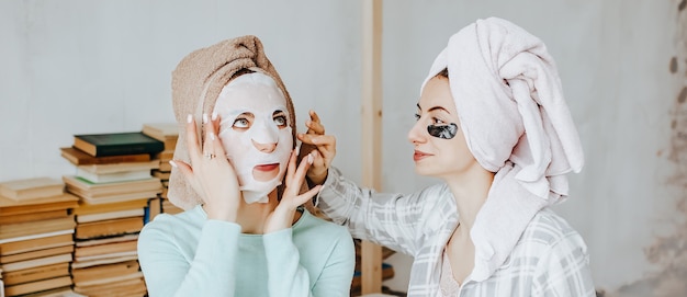 Duas garotas fazem máscaras e adesivos para a beleza do rosto e do cabelo