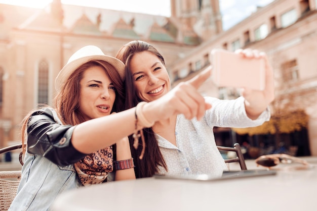 Duas garotas fazendo selfie no café