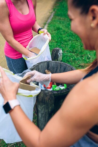 Duas garotas jogando lixo depois de plogging