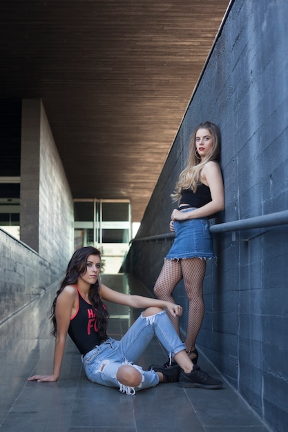 Duas garotas, morena e loira em pose de moda