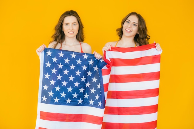 Duas garotas muito elegantes comemorando o dia da independência e se divertindo com a bandeira nacional dos eua