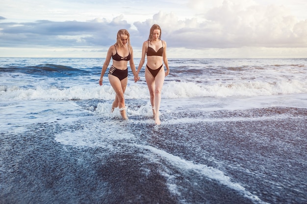 Duas garotas na praia fora da água