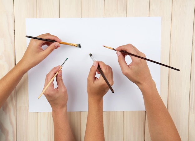 Foto duas garotas pintando com pincel e tintas coloridas