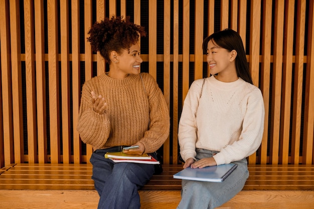 Duas garotas sentadas em um banco e conversando