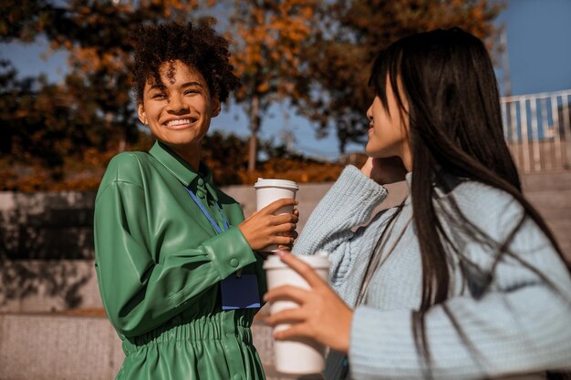 Duas garotas tomando café lá fora e conversando