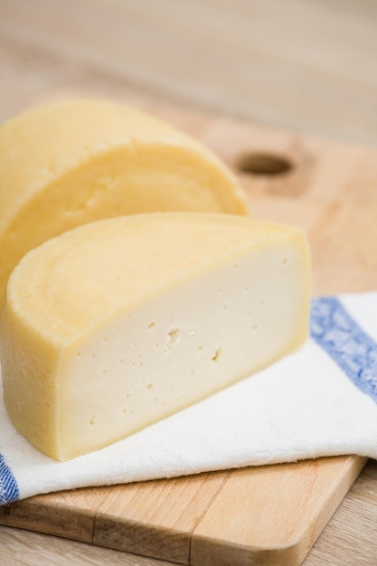 Foto duas grandes cabeças de queijo orgânico na mesa da cozinha da fazenda. conceito de comida.