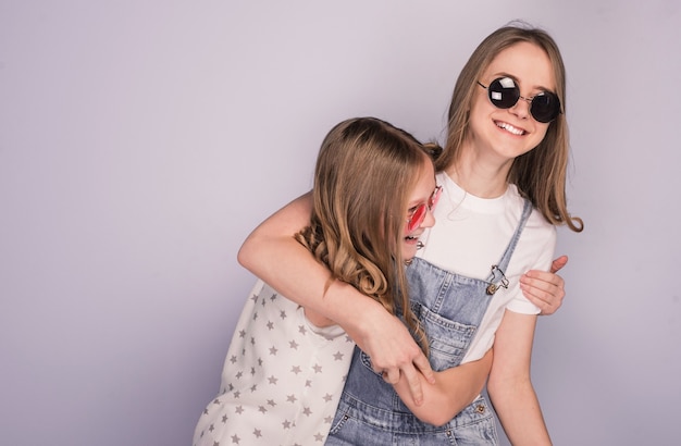 Duas irmãs adolescentes se divertindo rindo na frente da câmera sorrindo