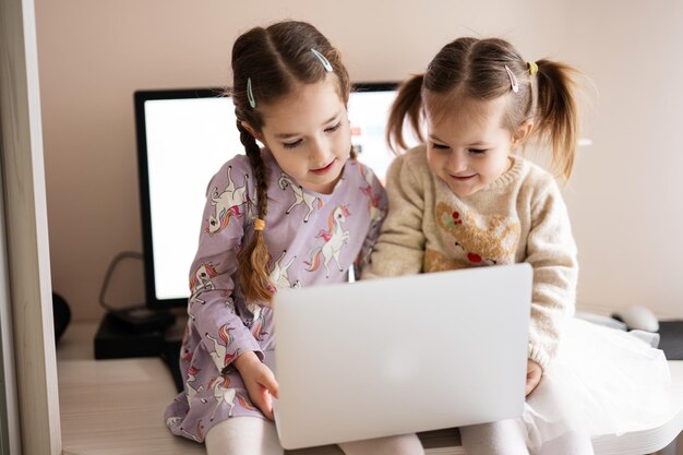 Duas irmãs assistindo no laptop Tecnologia e conceito de casa