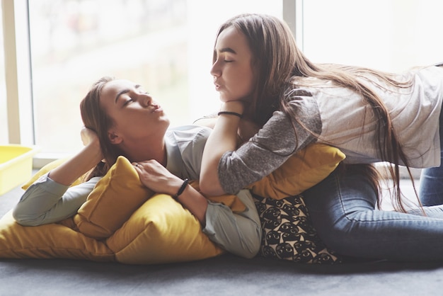 Duas irmãs gêmeas jovem bonita, passar um tempo junto com almofadas. Irmãos se divertindo em casa conceito