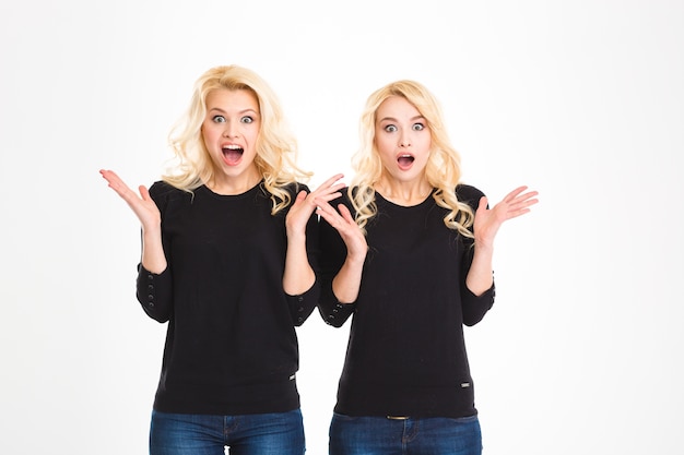 Foto duas irmãs gêmeas louras surpresas e chocadas