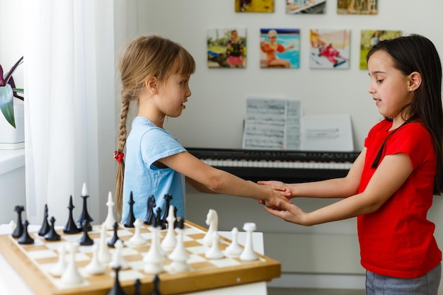 Duas irmãzinhas jogando xadrez em casa