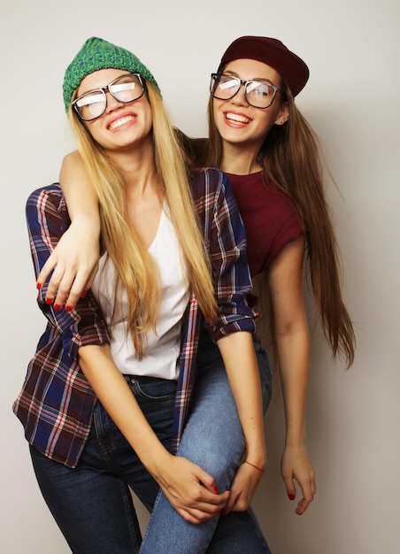 Foto duas jovens amigas de pé juntas e se divertindo