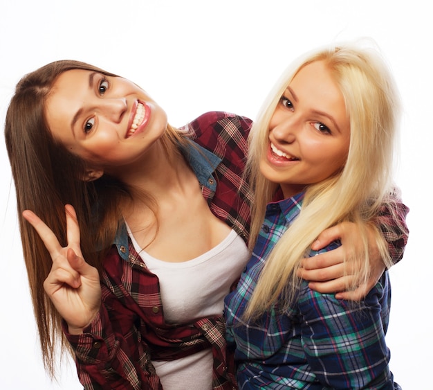 Duas jovens amigas juntas e se divertindo. mostrando sinais com as mãos. olhando para a câmera