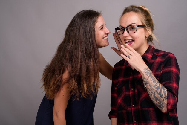 Foto duas jovens amigas lindas juntas em cinza