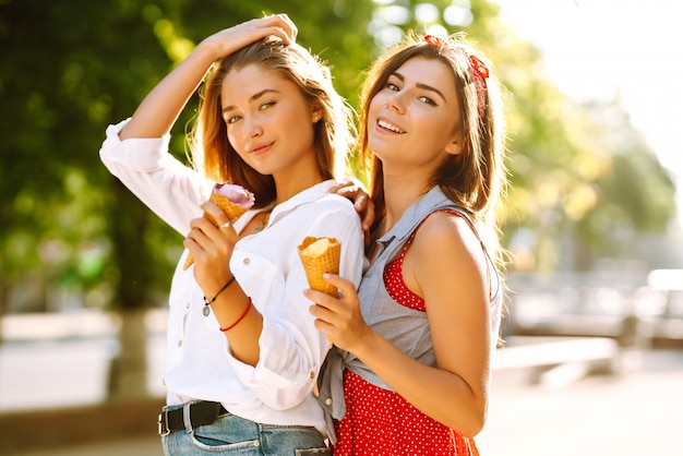 Duas jovens amigas se divertindo e tomando sorvete.